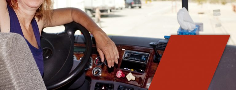 woman truck driver at wheel wondering if truck driving schools teach manual
