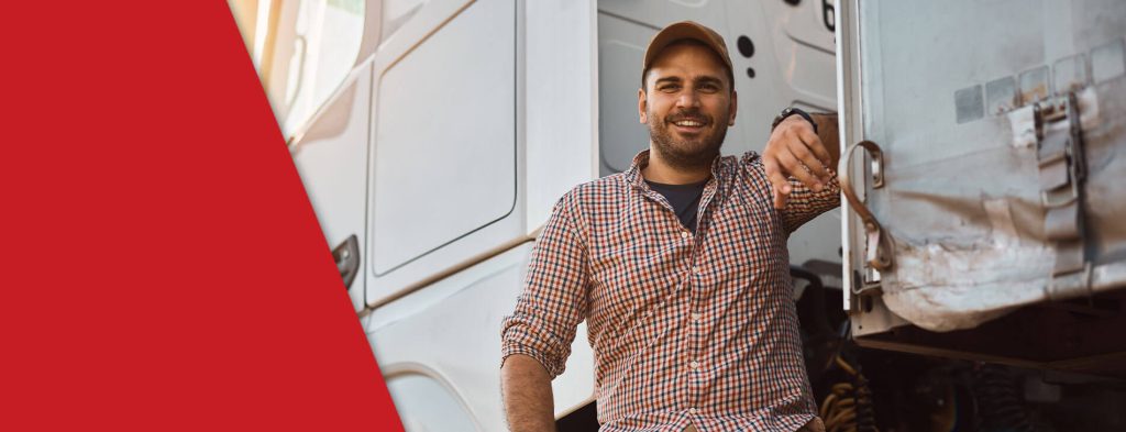 trucking industry driver posing next to white truck